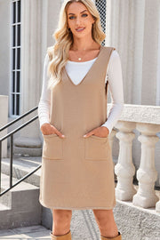 Sleeveless knit pocket dress in camel with V-neck and two front patch pockets.