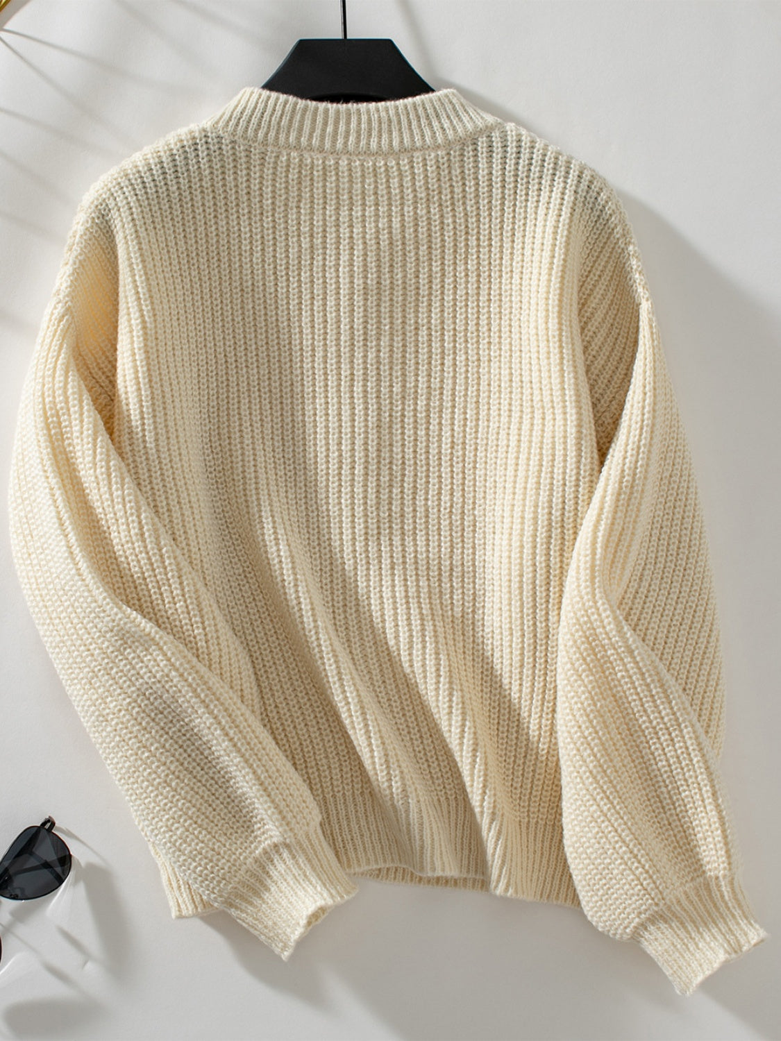Cream ribbed knit cardigan with mock neck and long sleeves.
