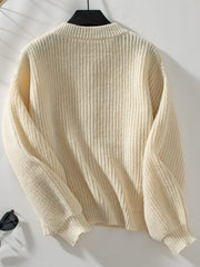 Cream ribbed knit cardigan with mock neck and long sleeves.