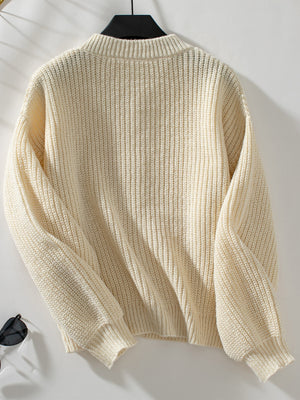 Cream ribbed knit cardigan with mock neck and long sleeves.