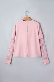 Pink maternity t-shirt with lace sleeves featuring bow details and a crew neck.