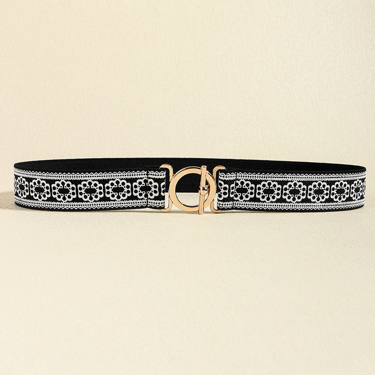 Black elastic belt with white lace trim and gold circle buckle