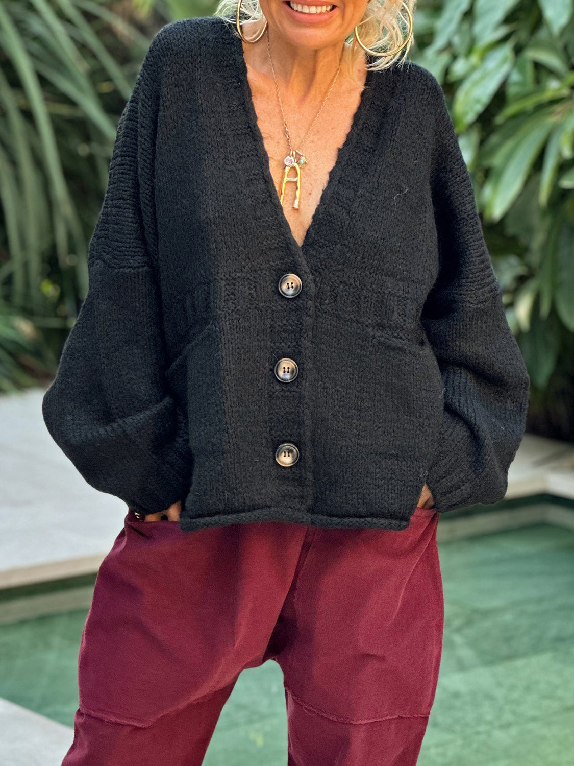 Black knit bouclé oversized button-down cardigan with V-neck and pockets.