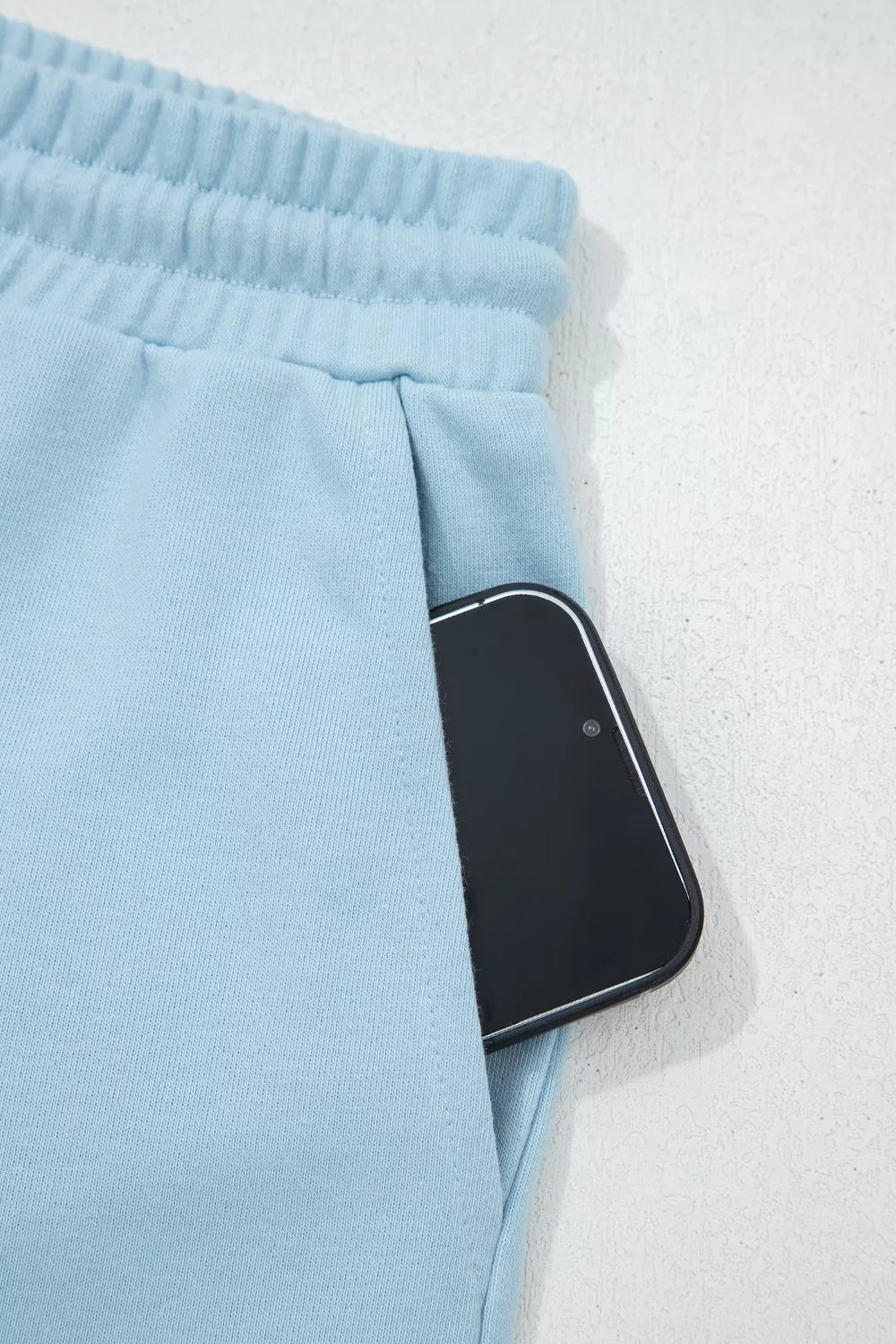 Light blue cotton bikini bottoms with drawstring waist and pocket detail.