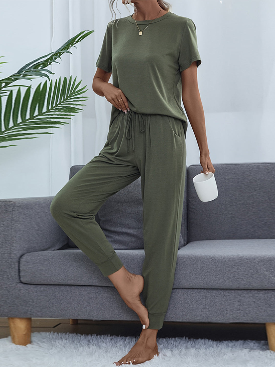 Moss green relaxed-fit tee and jogger set with drawstring waist and cuffed ankles.