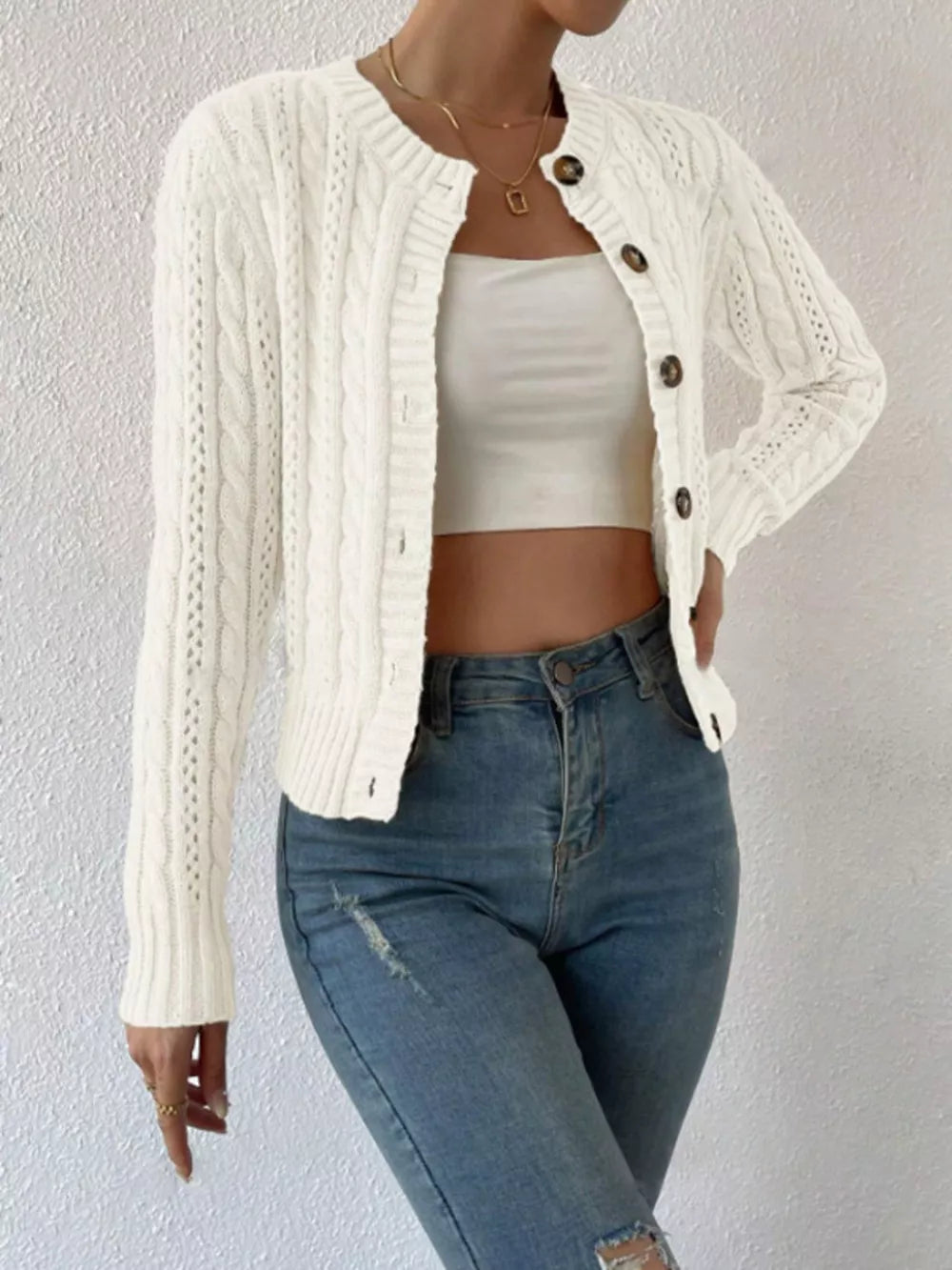 White cable-knit button-front cardigan with crew neck and long sleeves