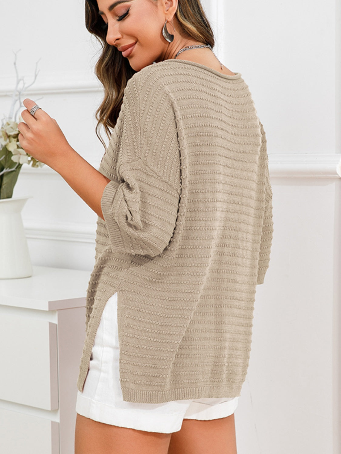Tan textured knit sweater with boat neck, short sleeves, and slit hem.
