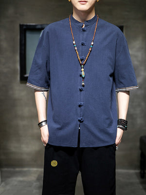 Blue cotton blend shirt with mandarin collar, frog buttons, and embroidered sleeve cuffs.