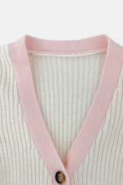 Cream acrylic knit cardigan with pink contrast trim and button closure.