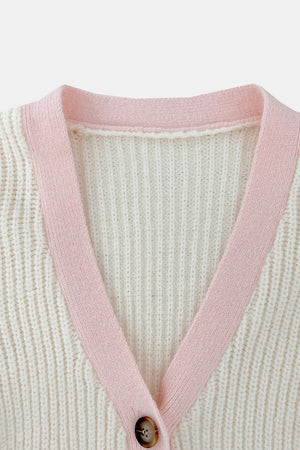 Cream acrylic knit cardigan with pink contrast trim and button closure.