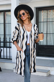 Longline knit cardigan in black and beige wave stripe pattern with pockets.