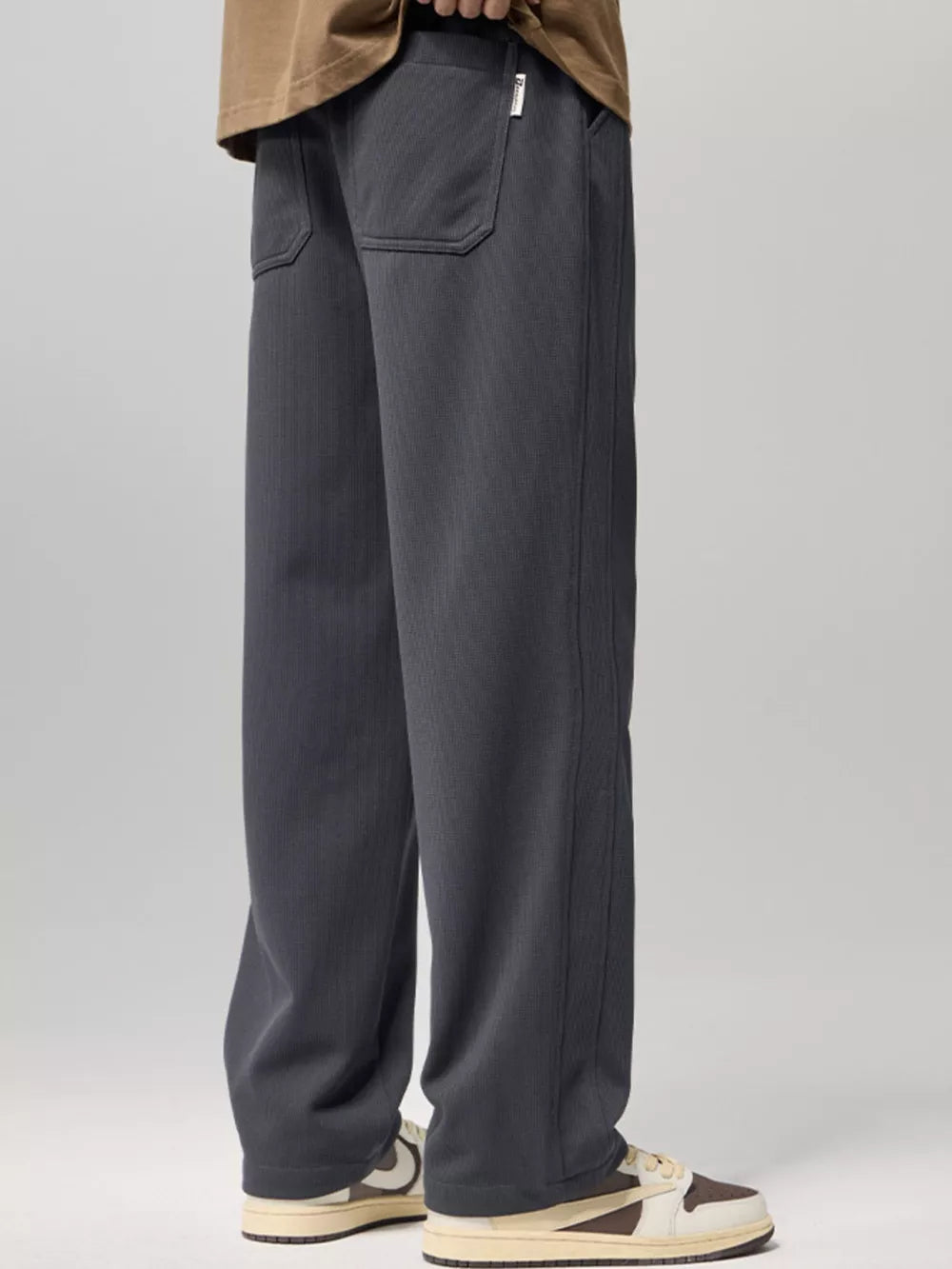 Relaxed fit gray drawstring sweatpants with back pockets and subtle vertical texture.
