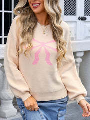 Blush pink bow graphic knit sweater with crew neck and long balloon sleeves.