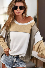 Colorblock knit top in tan, white, and grey with seam details and a slouchy fit.