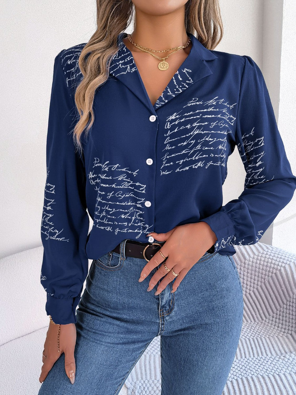 Dark blue collared blouse with white script pattern, button front, and long sleeves.