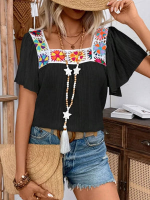 Black embroidered square neck flutter blouse with colorful floral detail.
