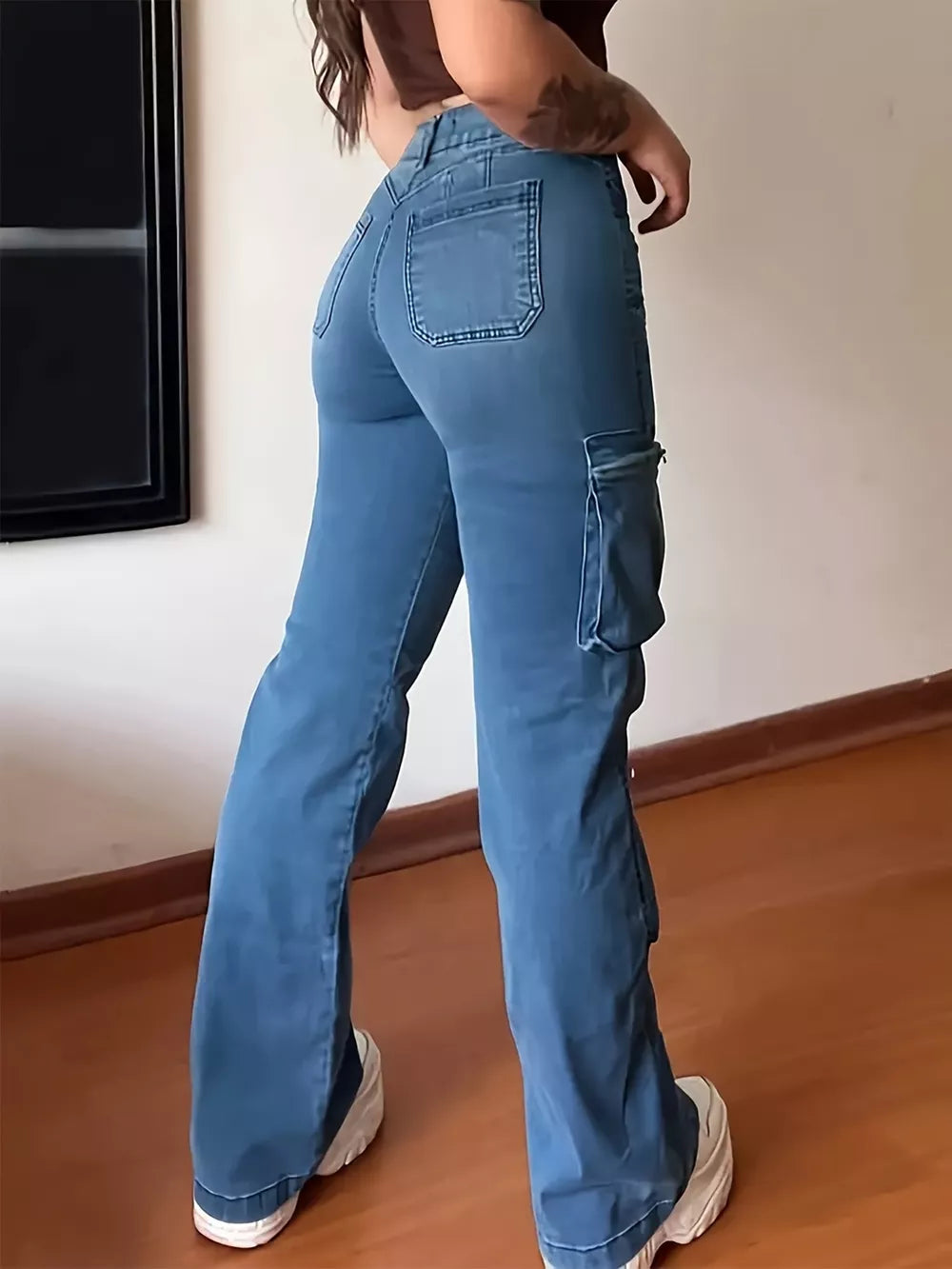 Blue cotton high-waisted cargo jeans with a buttoned closure and flared legs.