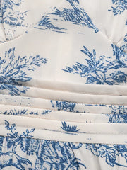 Toile print midi dress with blue scenic pattern, V-neck, and ruched waist detail.