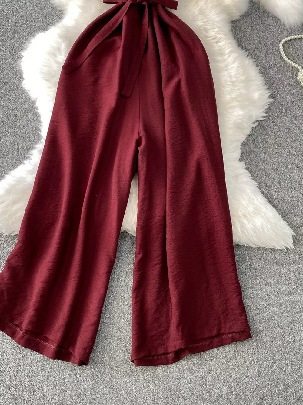 Burgundy V-neck wide leg jumpsuit with tie belt detail