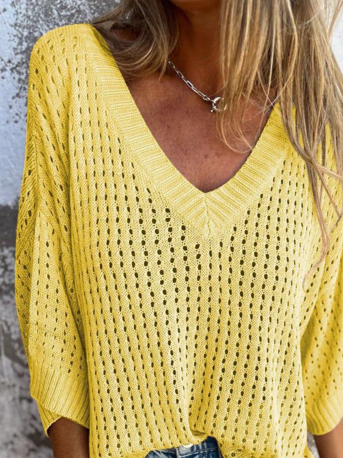 Yellow open-knit V-neck sweater with slouchy fit and detailed stitching.