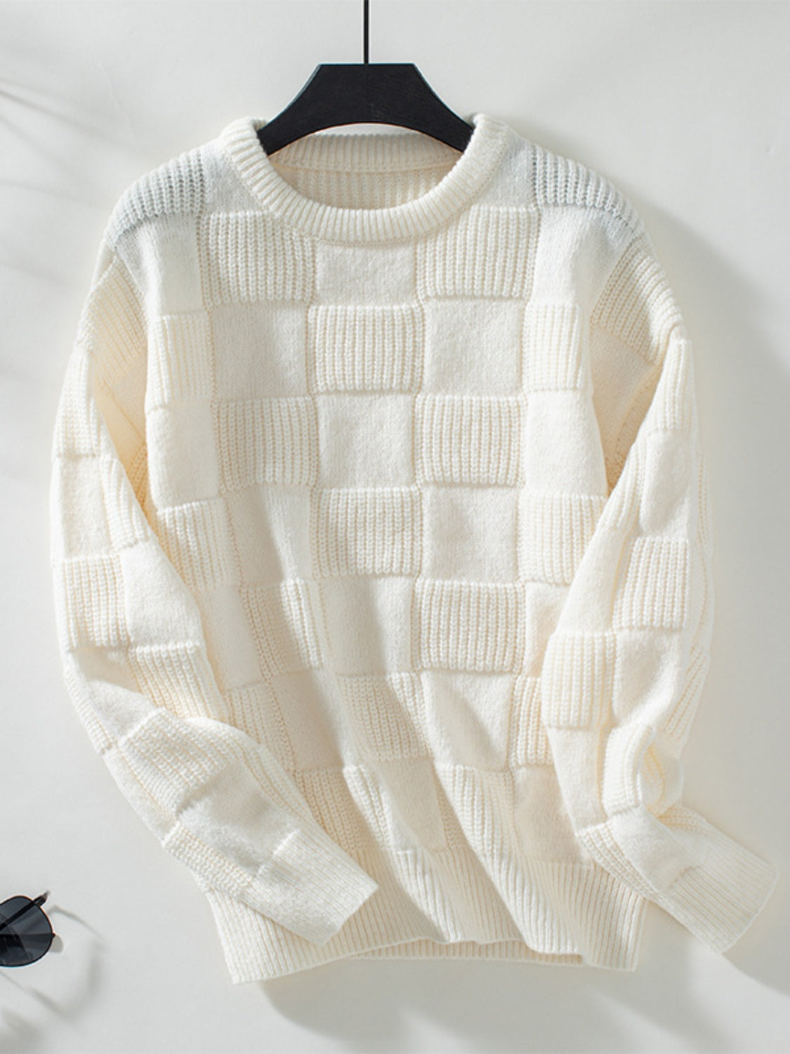 Cream textured checkerboard knit pullover sweater with crewneck and long sleeves.
