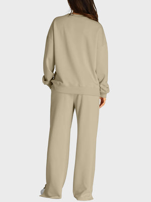 Tan loungewear set with crewneck sweatshirt and wide-leg trousers featuring slit fronts.