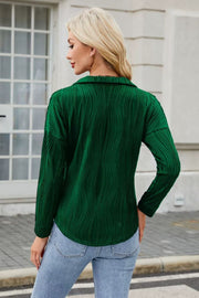 Dark green collared blouse with wave-effect texture and long sleeves.