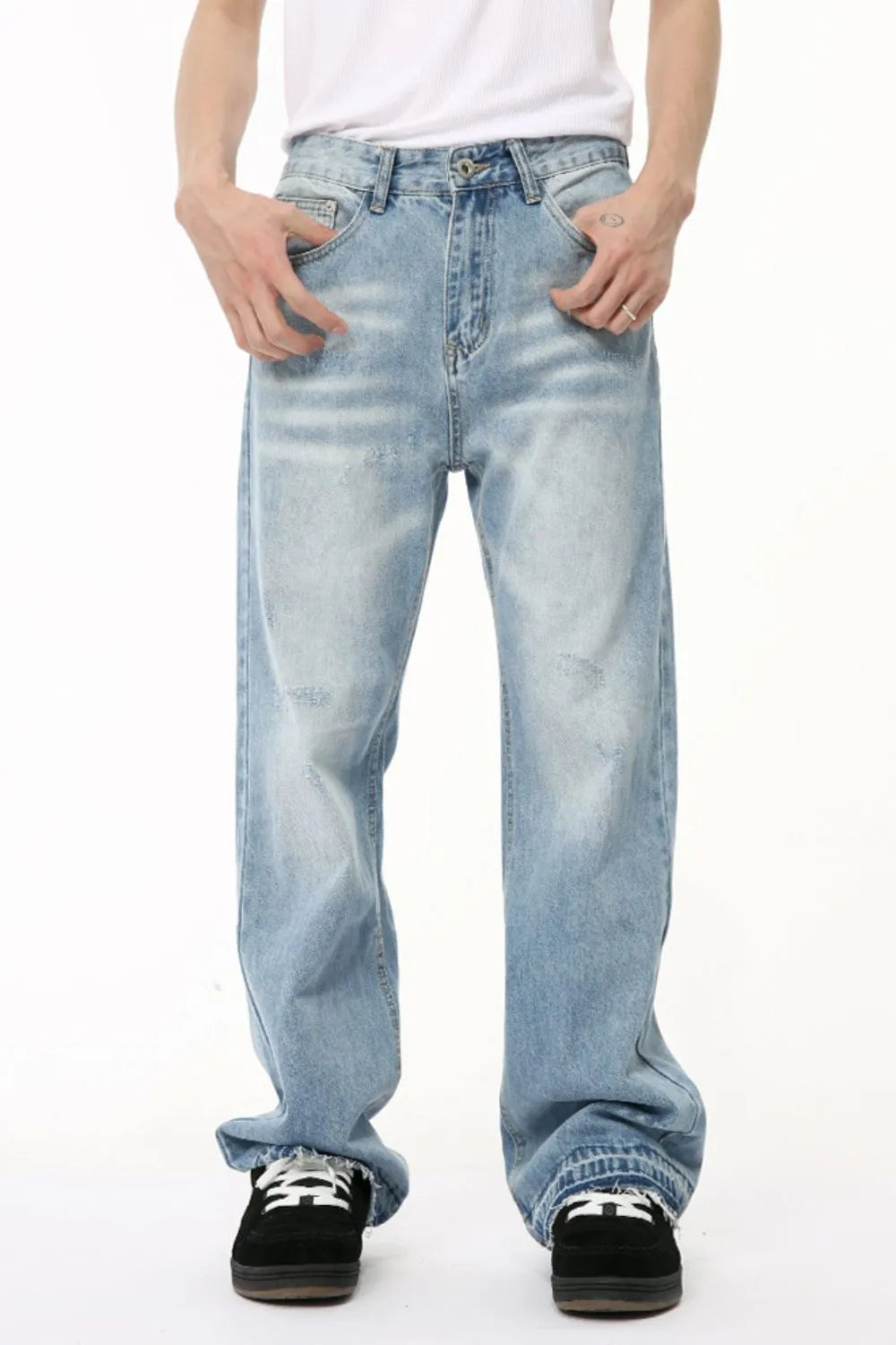 Baggy light wash denim jeans with distressed details and raw hem.