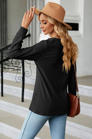Black textured henley blouse with button detail and long sleeves.