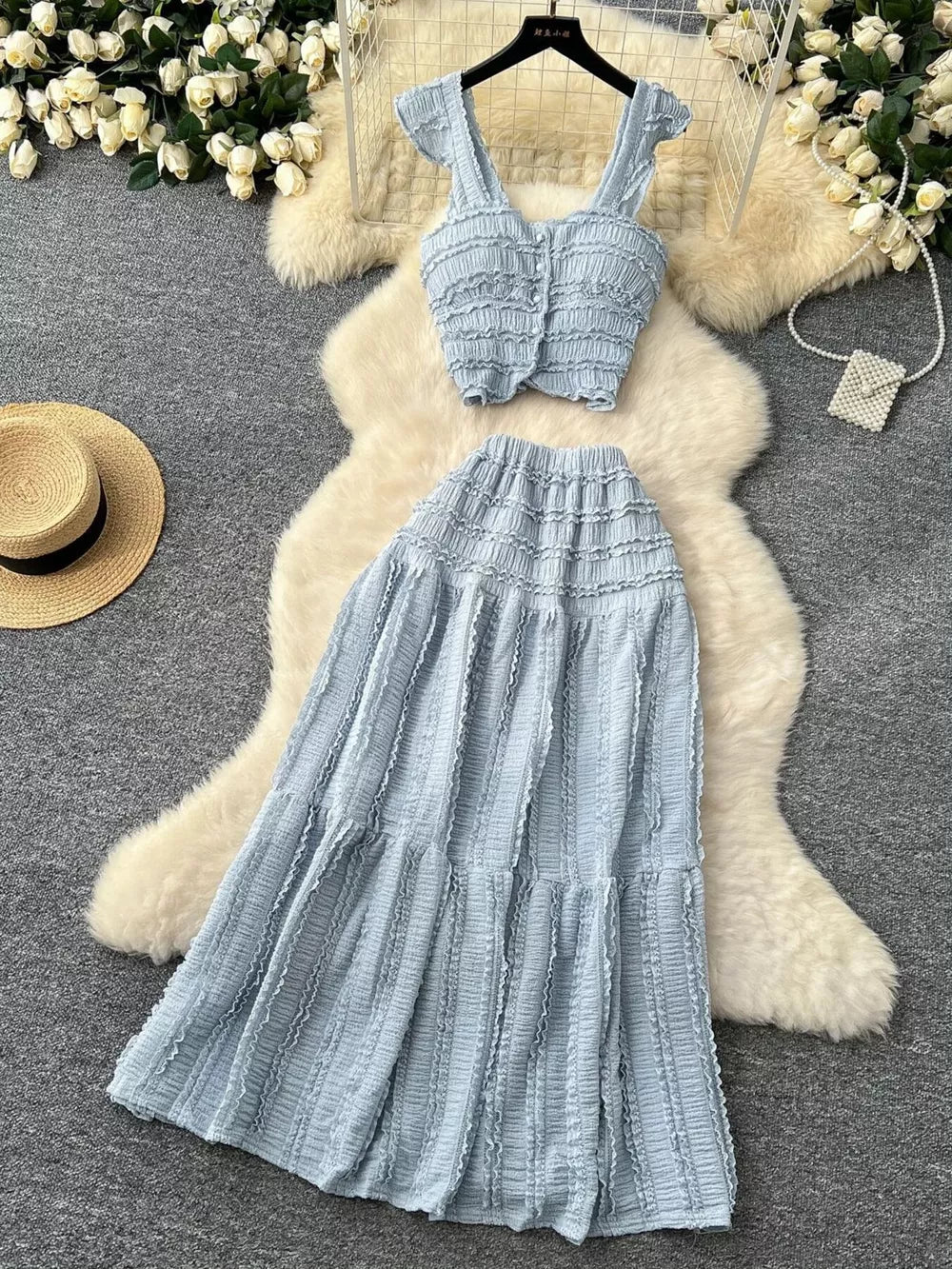 Light blue textured two-piece set with ruffled details, buttoned crop top and tiered maxi skirt.