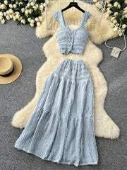 Light blue textured two-piece set with ruffled details, buttoned crop top and tiered maxi skirt.