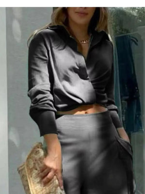 Black polyester two-piece set with collared crop top and pocketed pants.