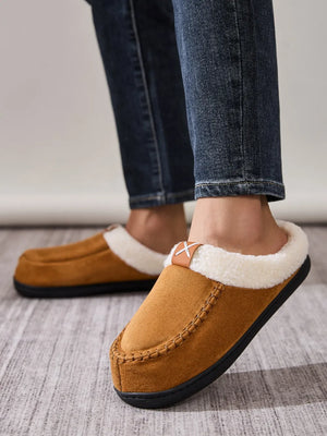 Caramel suede moccasin slides with shearling lining and decorative stitching.