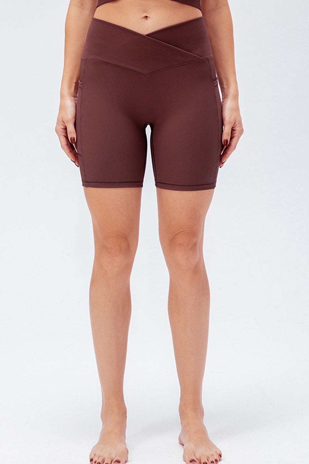 Cross-waist bike shorts in Burgundy with ribbed texture and side pockets.