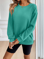 Teal relaxed fit sweatshirt with crewneck and long sleeves, styled casually.