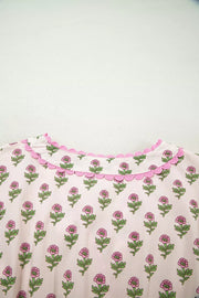 Floral v-neck midi dress in blush pink with scalloped trim and button front detail.