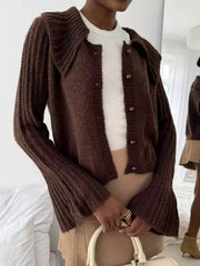 Chocolate acrylic cardigan with oversized collar and pearl buttons, featuring flared sleeves.