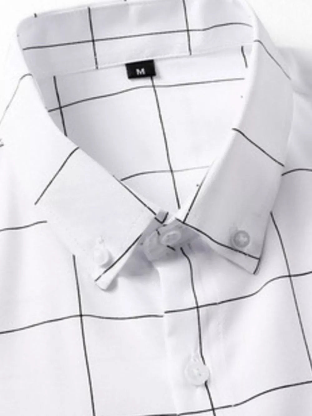 White cotton oversized button-down shirt with black plaid print and button collar.