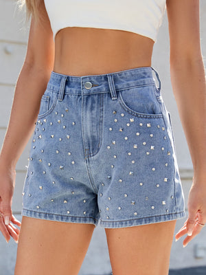 Medium wash denim high-waisted cutoff shorts with allover silver stud embellishments.