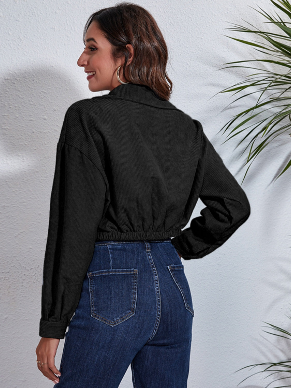 Black corduroy cropped utility jacket with elasticated hem and buttoned cuffs.