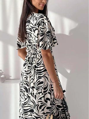 A-line midi dress with flutter sleeves and abstract black and white pattern.