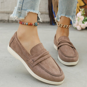 Classic round toe slip-on loafers in beige suede with a decorative strap detail.