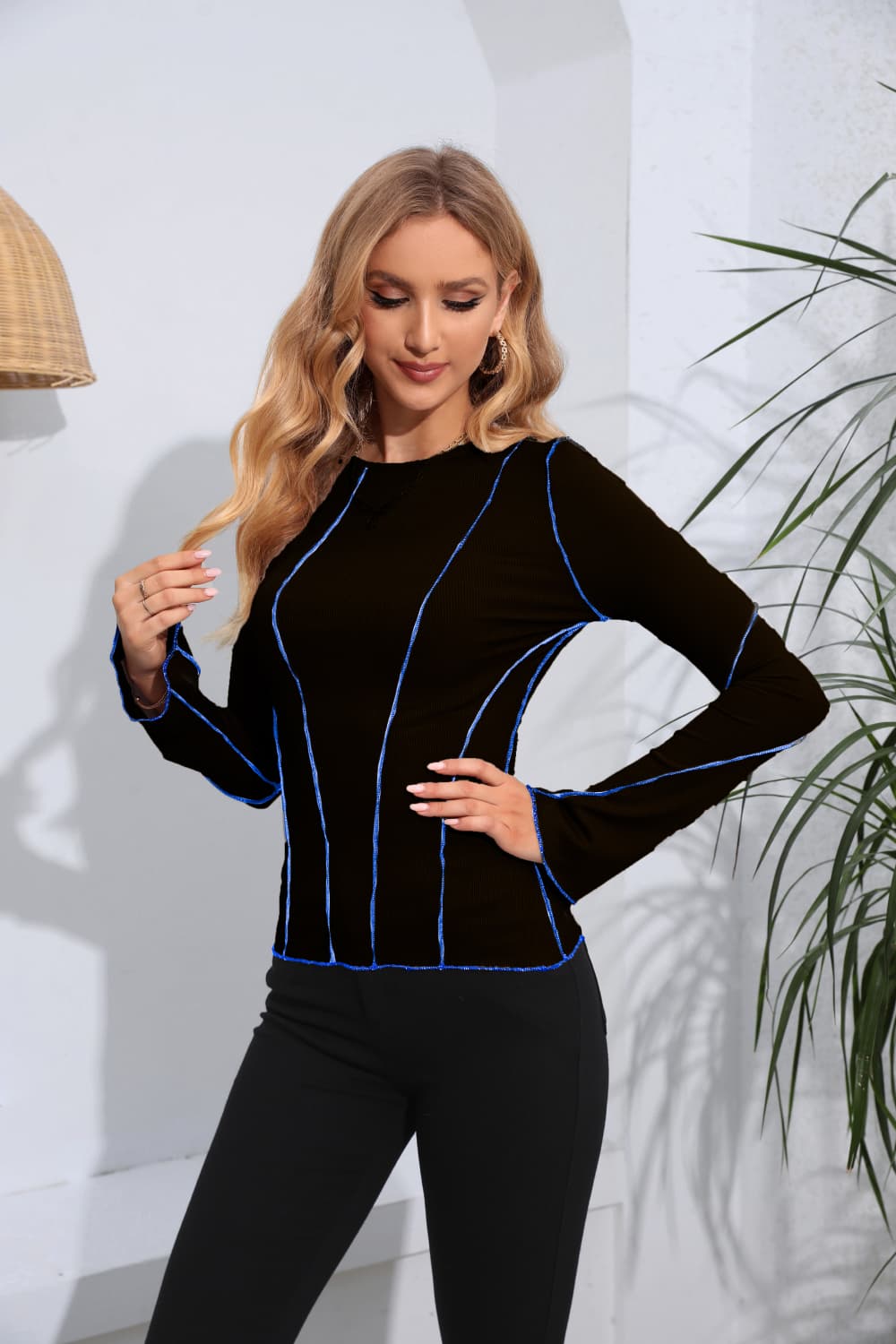 Black ribbed long sleeve top with contrast blue stitching and a crew neck.