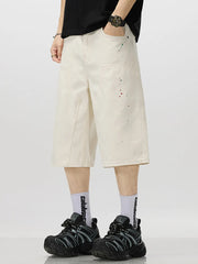 Cream cotton denim capris for him with artistic paint splatter detail.