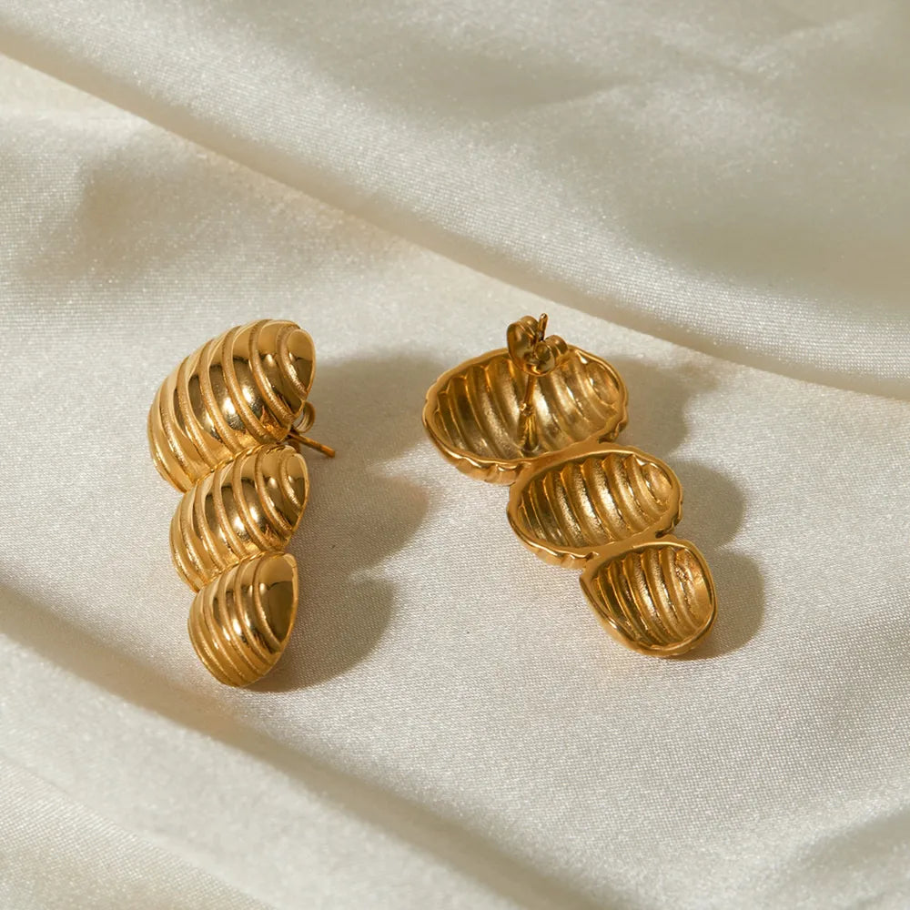 Gold drop earrings with sculptural spiral design, 18K gold-plated.