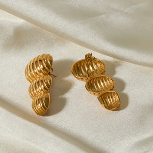 Gold drop earrings with sculptural spiral design, 18K gold-plated.
