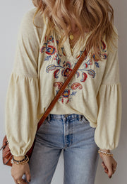 Pastel yellow embroidered blouse with poet sleeves and a V-neckline.