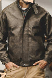 Distressed leather bomber jacket in dark gray with stand collar and elastic cuffs.