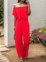 Red off-the-shoulder flounce jumpsuit with wide legs and a cinched waist.