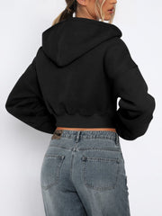 Black cropped zip-up hoodie with ribbed hem and full sleeves, shown from the back.